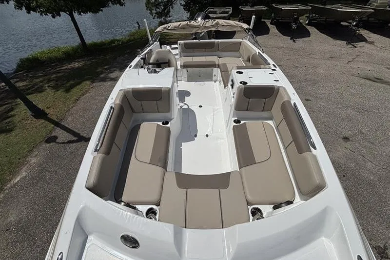Slide: The Image of 2026 Tahoe 2150 boat with spacious seating, docked near a serene lake. - 5
