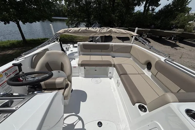 Slide: The Image of 2026 Tahoe 2150 boat interior with beige seating, steering wheel, and lake view. - 6