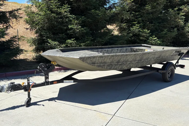 Slide: The Image of 2026 Tracker Grizzly 1860 Utility boat on trailer, parked outdoors. - 3