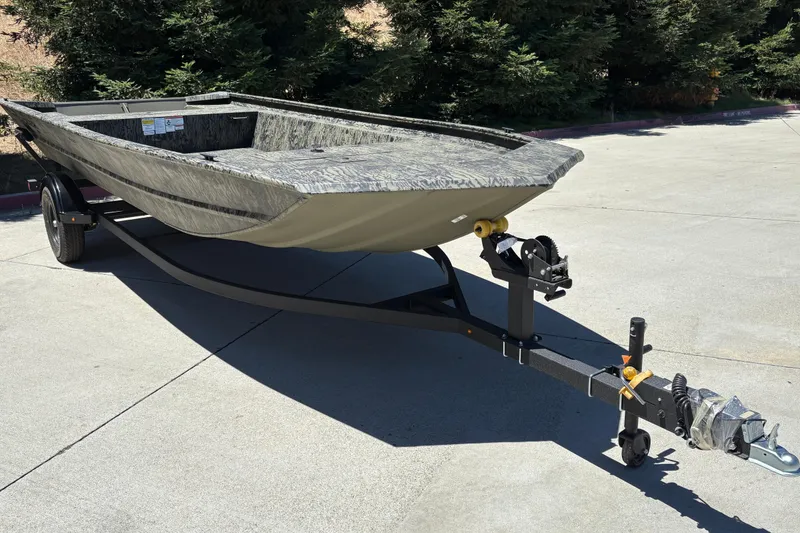 Slide: The Image of 2026 Tracker Grizzly 1860 Utility boat on trailer, parked outdoors. - 9