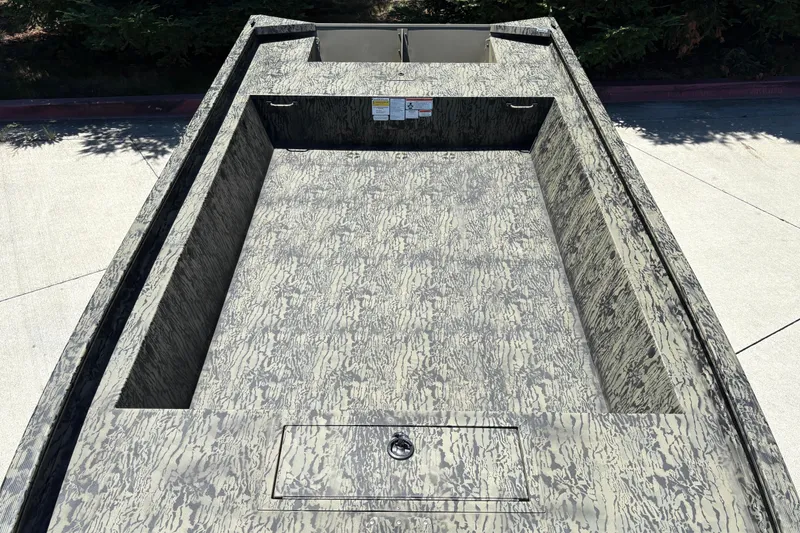 Slide: The Image of 2026 Tracker Grizzly 1860 Utility boat with camouflage pattern on a concrete surface. - 11