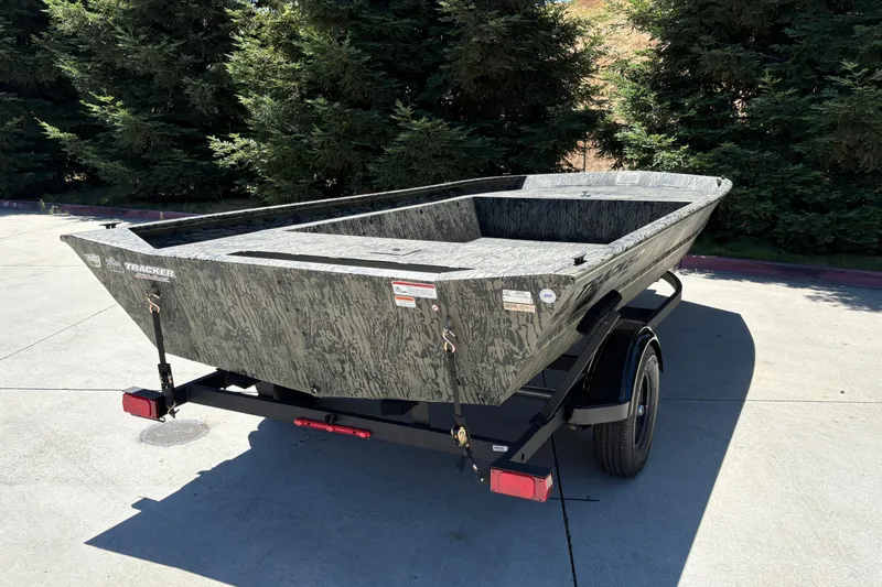 Slide: The Image of 2026 Tracker Grizzly 1860 Utility boat on trailer, parked outdoors. - 14