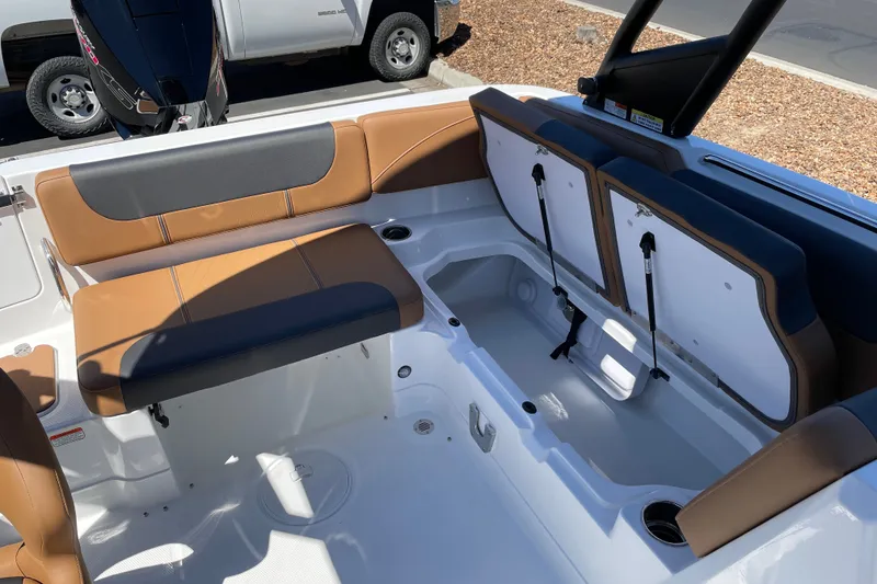 Slide: The Image of 2026 Tahoe 1950 boat interior with brown and gray seating, storage compartments open. - 19