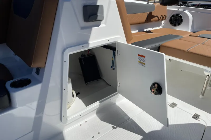 Slide: The Image of Open storage compartment in 2026 Tahoe 1950 boat interior, featuring brown seating and modern design. - 25