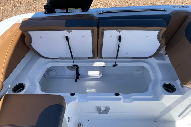 Slide: The Image of Open storage compartment in 2026 Tahoe 1950 boat with brown and blue seating. - 18