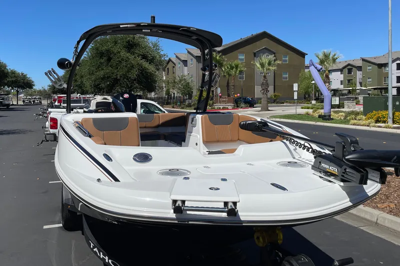 Slide: The Image of 2026 Tahoe 1950 boat with Minn Kota motor, parked in urban setting under clear blue sky. - 3