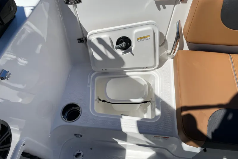 Slide: The Image of Open storage compartment in 2026 Tahoe 1950 boat with tan seating and cup holder. - 20