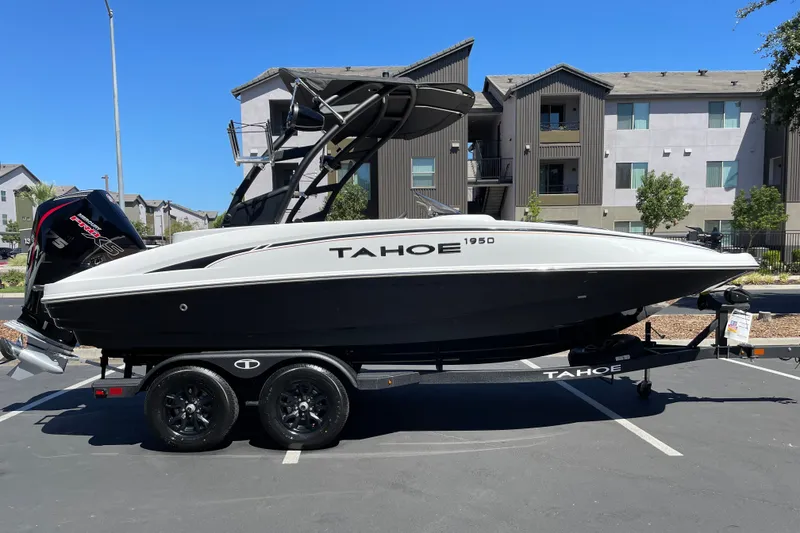 The Image of 2026 Tahoe 1950 boat on trailer, parked in urban setting, under clear blue sky. - 0