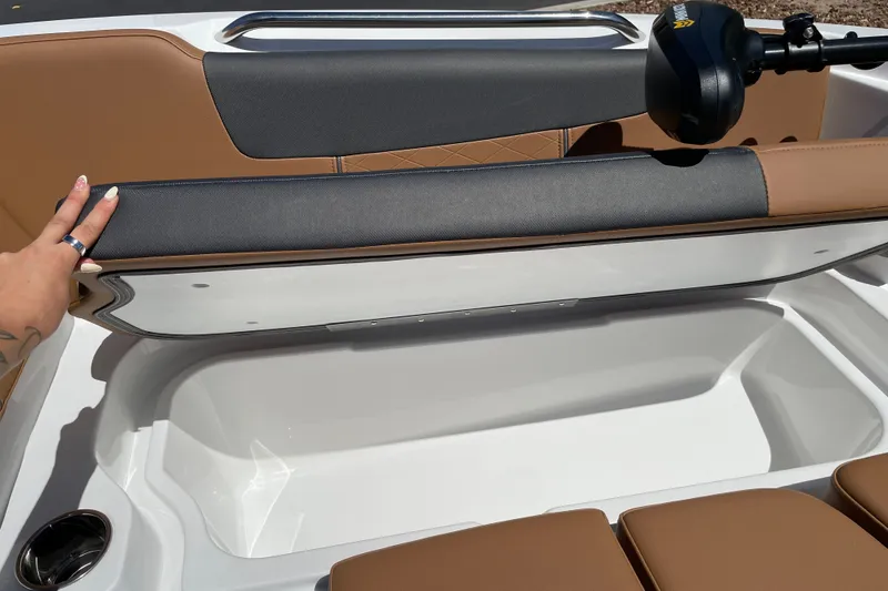 Slide: The Image of 2026 Tahoe 1950 boat interior with storage compartment and brown seating. - 31