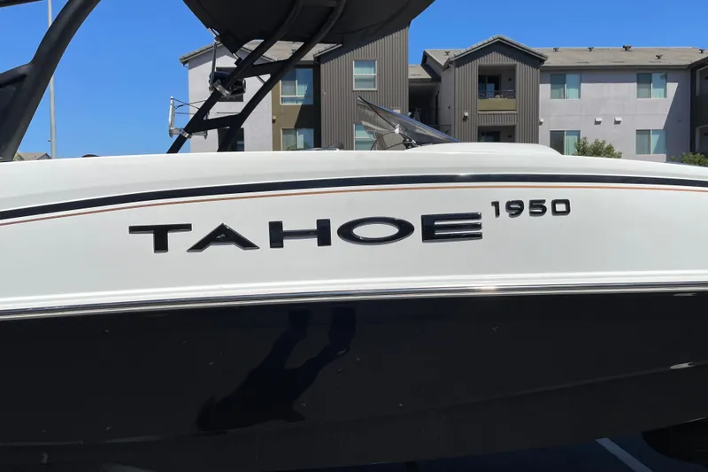 Slide: The Image of 2026 Tahoe 1950 boat side view with modern design, parked near residential buildings. - 40