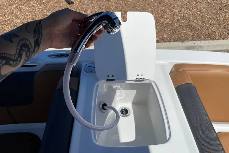 Slide: The Image of Hand holding a chrome faucet over a boat sink on a 2026 Tahoe 1950 model. - 29