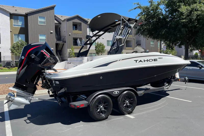 Slide: The Image of 2026 Tahoe 1950 boat on trailer, parked in urban setting, featuring sleek design and powerful engine. - 1