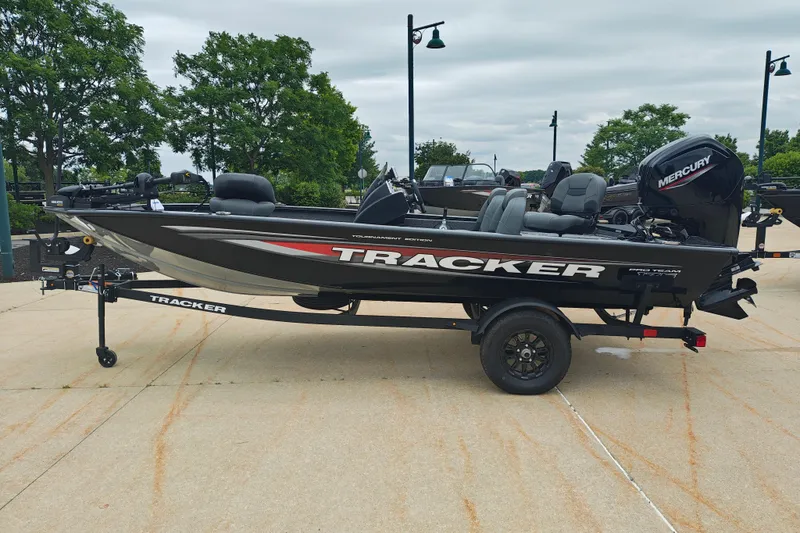 The Image of 2026 Tracker Pro Team 175 boat on trailer, parked outdoors with trees in background. - 1