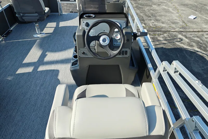 Slide: The Image of 2026 Sun Tracker Bass Buggy 18 DLX pontoon boat interior with steering console and seating. - 13