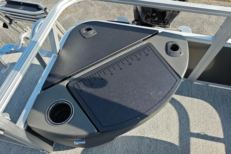 Slide: The Image of 2026 Sun Tracker Bass Buggy 18 DLX fishing station with measuring board and cup holders. - 18