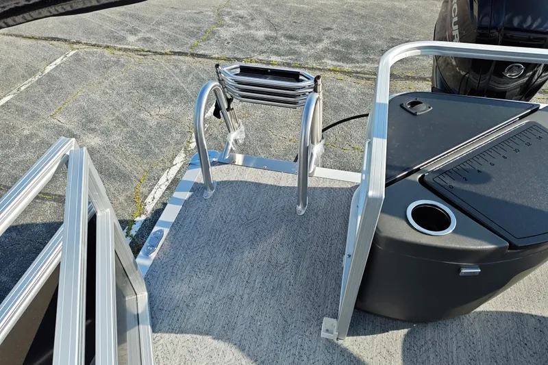 Slide: The Image of 2026 Sun Tracker Bass Buggy 18 DLX boat ladder and deck area with motor. - 19