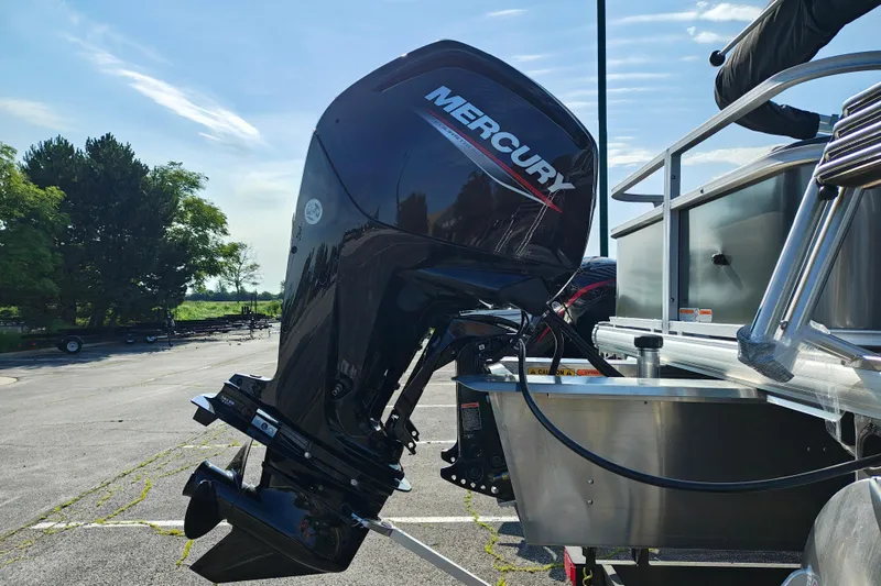 Slide: The Image of 2026 Sun Tracker Bass Buggy 18 DLX with Mercury outboard motor in a parking lot. - 4