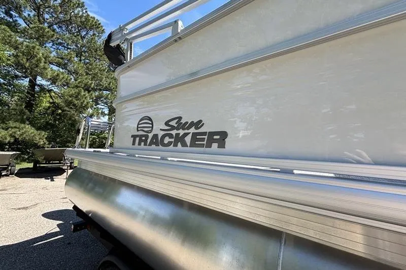 Slide: The Image of 2026 Sun Tracker Party Barge 20 DLX pontoon boat, side view with logo, outdoors. - 10
