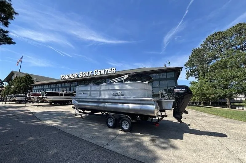 Slide: The Image of 2026 Sun Tracker Party Barge 20 DLX at Tracker Boat Center under clear blue sky. - 11