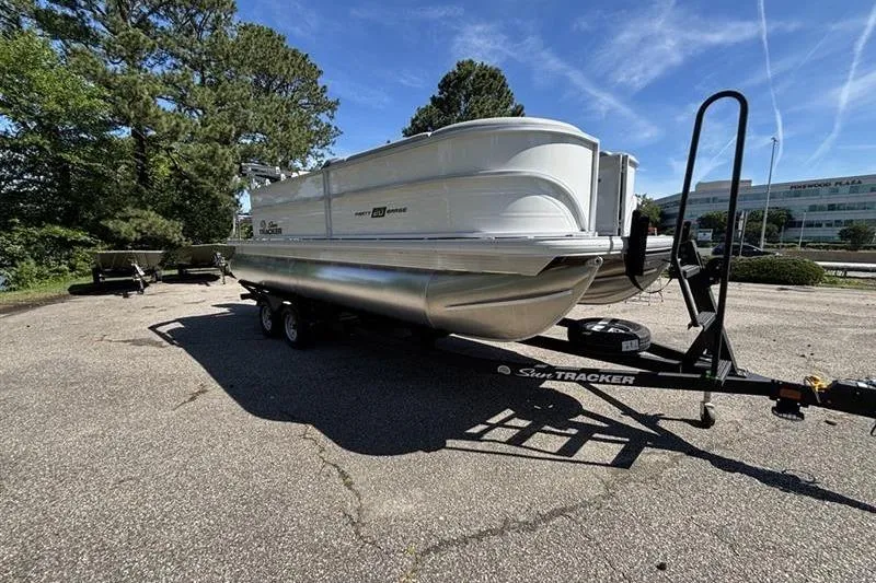 Slide: The Image of 2026 Sun Tracker Party Barge 20 DLX pontoon boat on trailer in parking lot. - 3