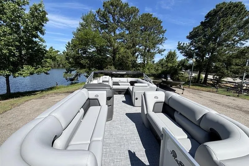 Slide: The Image of 2026 Sun Tracker Party Barge 20 DLX pontoon boat with spacious seating, parked by a scenic lake. - 5