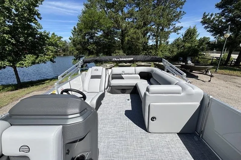 Slide: The Image of 2026 Sun Tracker Party Barge 20 DLX pontoon boat with spacious seating by a serene lake. - 9