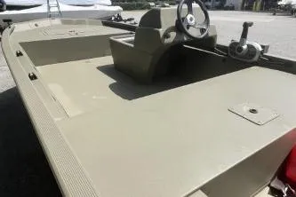 Slide: The Image of 2026 Tracker Grizzly 1648 SC boat with steering console, beige deck, and outdoor setting. - 8
