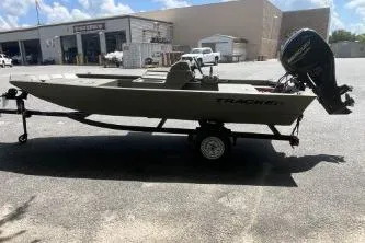 Slide: The Image of 2026 Tracker Grizzly 1648 SC boat on trailer, parked outdoors. - 2
