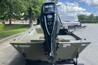 Slide: The Image of 2026 Tracker Grizzly 1648 SC boat with powerful outboard motor, parked outdoors. - 3