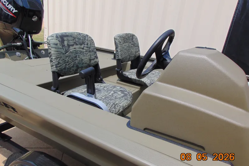 Slide: The Image of 2026 Tracker Grizzly 1754 SC boat interior with camouflage seats and steering console. - 19