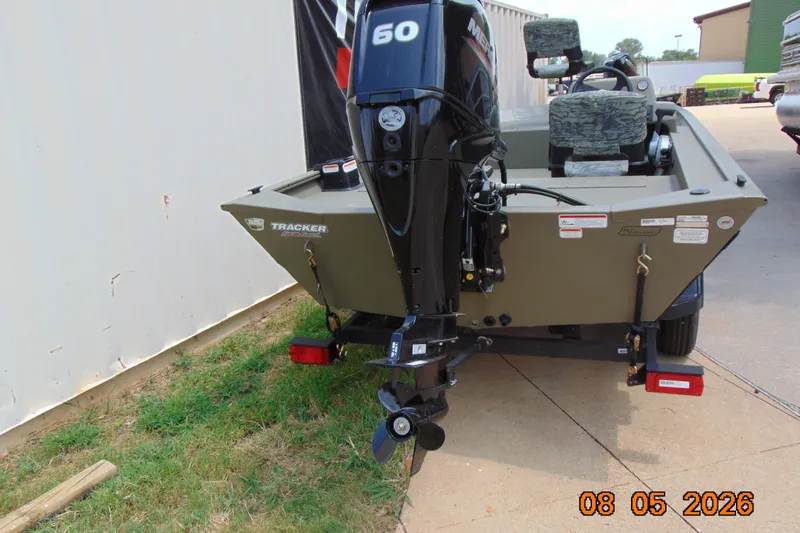 Slide: The Image of 2026 Tracker Grizzly 1754 SC boat with Mercury 50 engine, parked outdoors. - 13