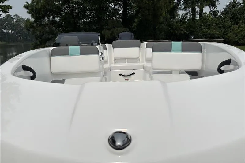 Slide: The Image of 2026 Tahoe T16 boat interior with white and gray seating, surrounded by trees. - 8