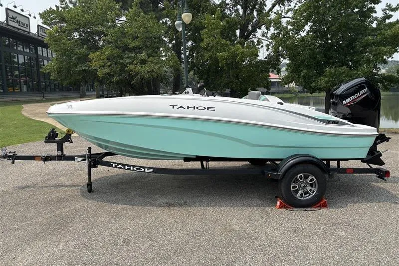 The Image of 2026 Tahoe T16 boat on trailer, parked outdoors near trees and water. - 0
