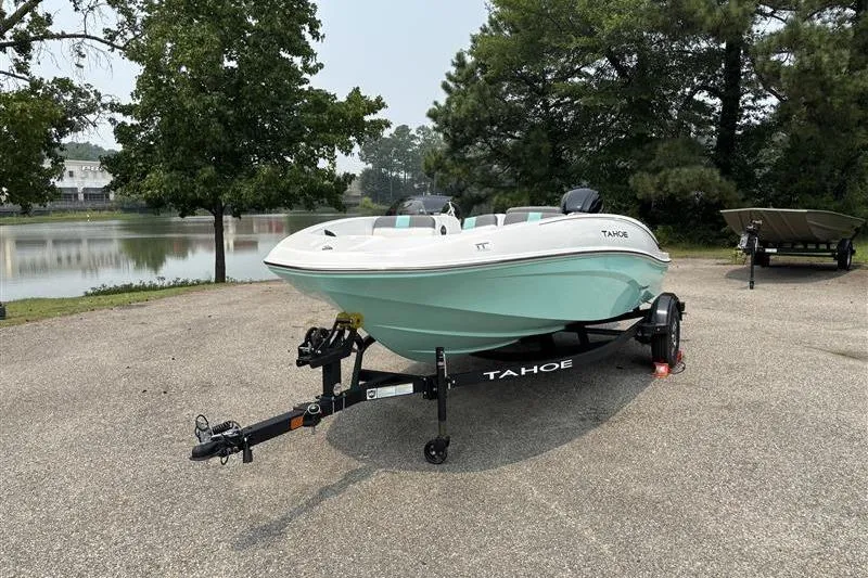 Slide: The Image of 2026 Tahoe T16 boat on trailer by a serene lake, surrounded by trees. - 1