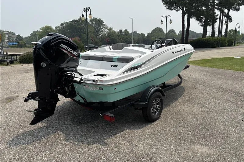 Slide: The Image of 2026 Tahoe T16 boat with Mercury engine on trailer, parked outdoors. - 4