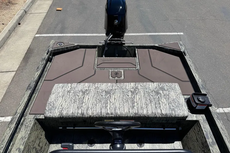 Slide: The Image of 2026 Tracker Grizzly 1860 CC boat with camouflage design, parked on asphalt. - 9