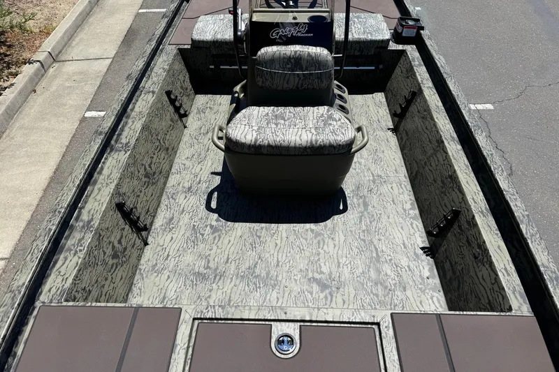 Slide: The Image of 2026 Tracker Grizzly 1860 CC boat interior with camouflage design and seating. - 8