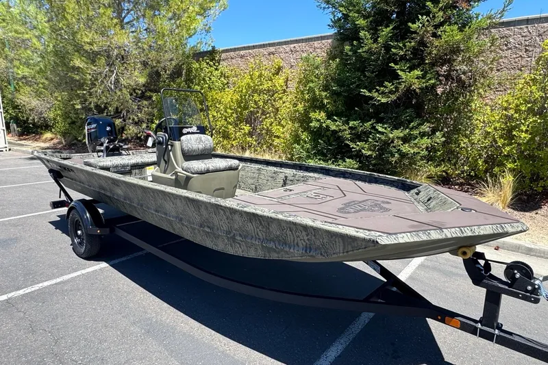 Slide: The Image of 2026 Tracker Grizzly 1860 CC boat on trailer in parking lot. - 2
