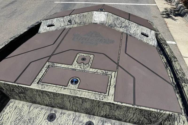 Slide: The Image of 2026 Tracker Grizzly 1860 CC boat deck with camouflage design and storage compartments. - 7
