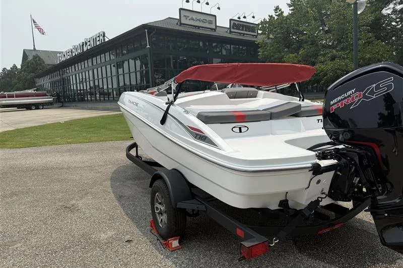 Slide: The Image of 2026 Tahoe T18 boat with red canopy on trailer outside dealership. - 5