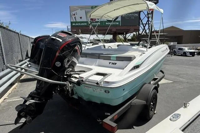 Slide: The Image of 2026 Tahoe T18 boat with outboard motor on trailer, parked outdoors. - 3