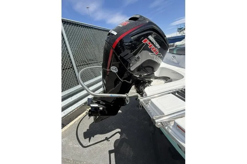 Slide: The Image of 2026 Tahoe T18 boat with Mercury Pro XS outboard motor, parked near a chain-link fence. - 7