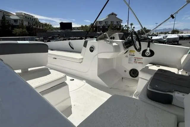 Slide: The Image of 2026 Tahoe T18 boat interior with seating and steering wheel, parked outdoors. - 8
