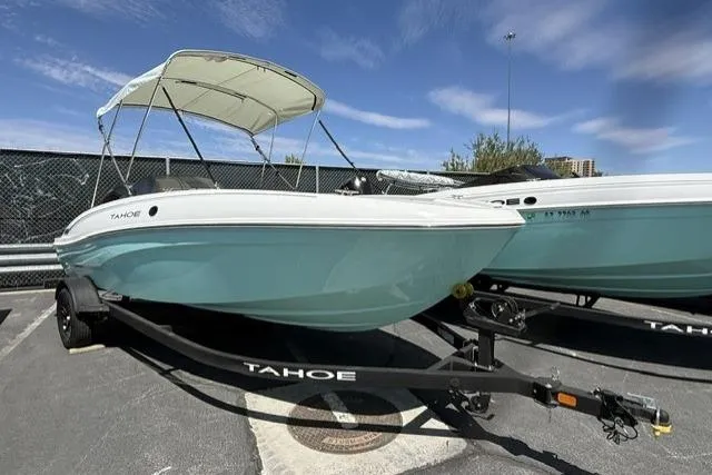 The Image of 2026 Tahoe T18 boat with canopy on trailer, parked outdoors under blue sky. - 0