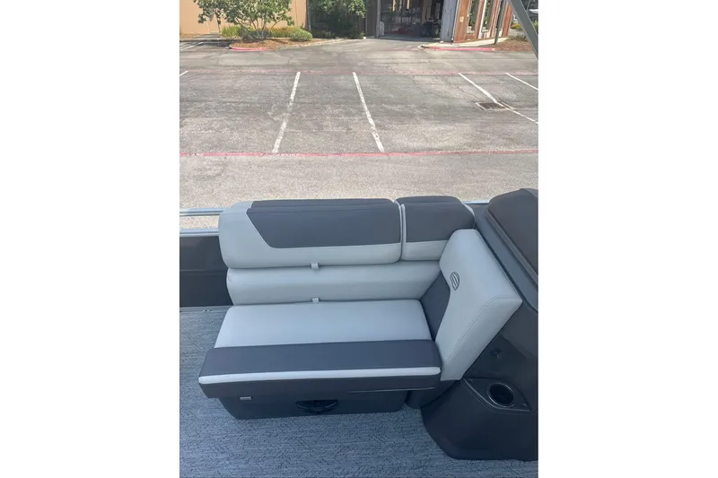 Slide: The Image of 2026 Sun Tracker Fishin' Barge 20 DLX boat seat, gray and black upholstery, outdoor setting. - 7