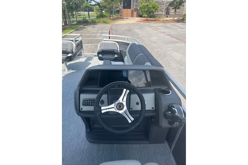 Slide: The Image of 2026 Sun Tracker Fishin' Barge 20 DLX steering console with modern controls and seating. - 9