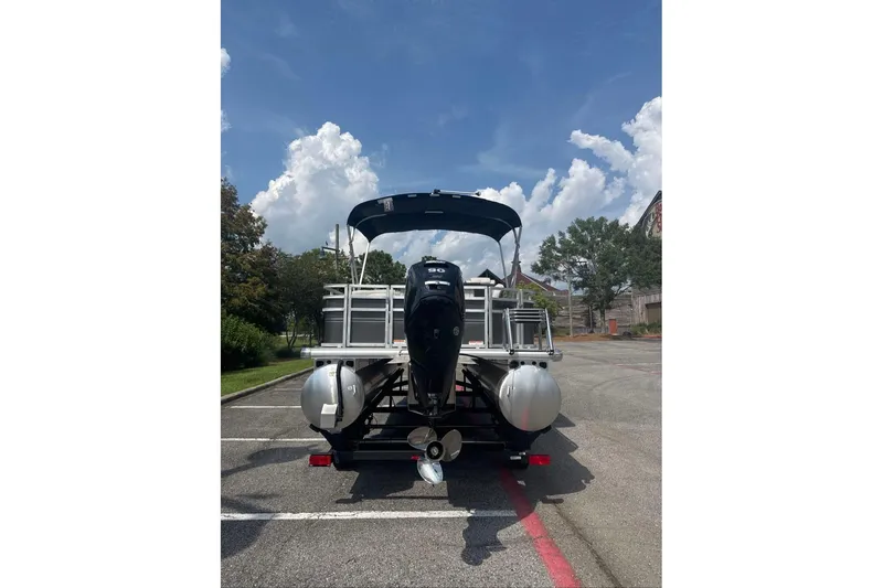 Slide: The Image of 2026 Sun Tracker Fishin' Barge 20 DLX pontoon boat parked under a clear blue sky. - 3
