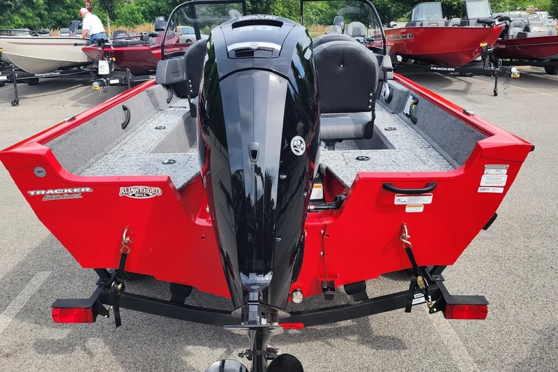 Slide: The Image of 2026 Tracker Pro Guide V-16 WT boat, red exterior, parked with outboard motor. - 4