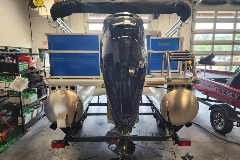 Slide: The Image of 2026 Sun Tracker Party Barge 18 DLX pontoon boat in a garage setting. - 2