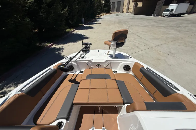 Slide: The Image of 2026 Tahoe 1950 boat interior with tan and black seating, docked outdoors. - 8
